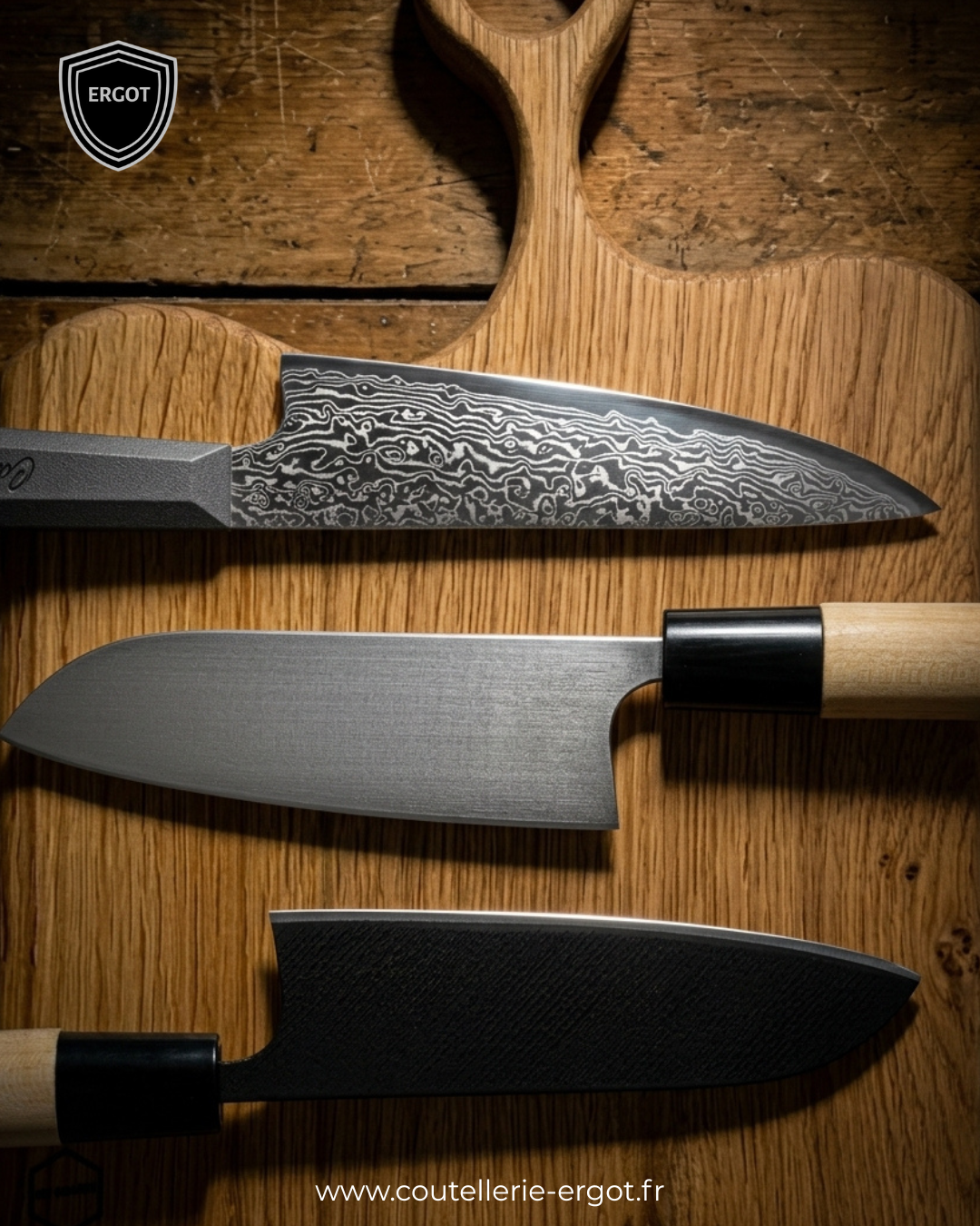 Trois couteaux de cuisine artisanaux alignés sur une planche en bois, lames damassées et fines, avec logo Ergot en haut à gauche. site www.coutellerie-ergot.fr en bas.